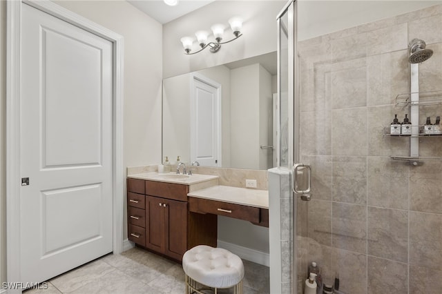 bathroom with a shower with door, vanity, and tile patterned flooring