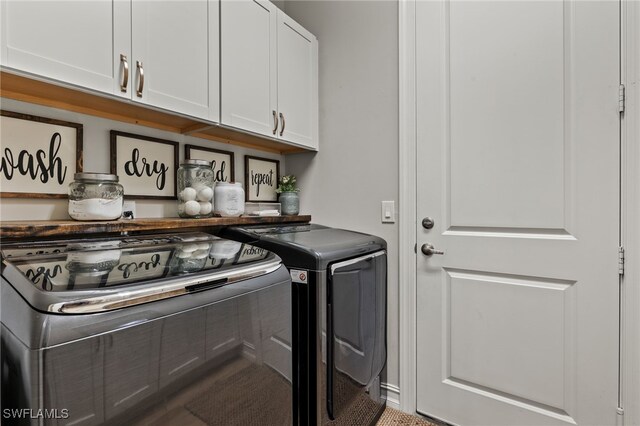 clothes washing area with cabinets and washer and dryer