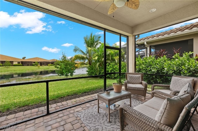 sunroom / solarium with a water view and ceiling fan