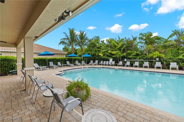 community pool featuring a patio area and fence