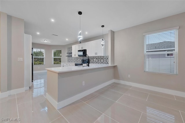 kitchen with kitchen peninsula, white cabinetry, light tile patterned flooring, and black appliances