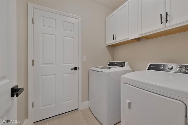 laundry room with separate washer and dryer, light tile patterned flooring, and cabinets