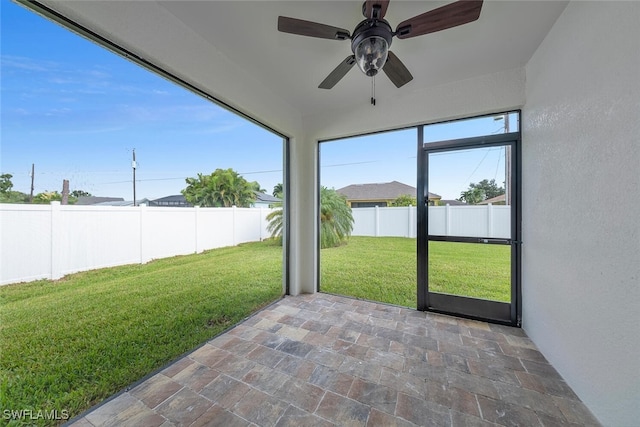 unfurnished sunroom with ceiling fan