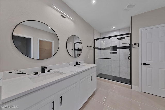 bathroom with tile patterned flooring, vanity, and walk in shower