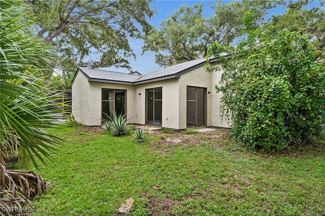 rear view of house featuring a yard