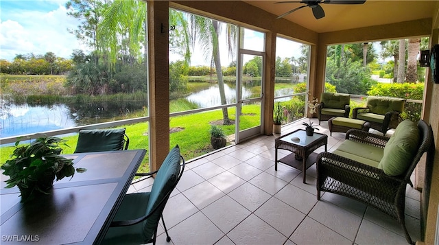 sunroom featuring ceiling fan, a healthy amount of sunlight, and a water view