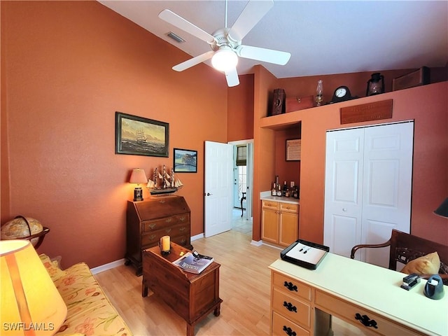 interior space with visible vents, baseboards, vaulted ceiling, a ceiling fan, and light wood finished floors