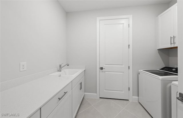 clothes washing area featuring independent washer and dryer, cabinets, sink, and light tile patterned floors