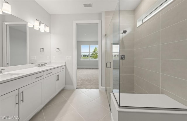 bathroom with walk in shower, vanity, and tile patterned flooring