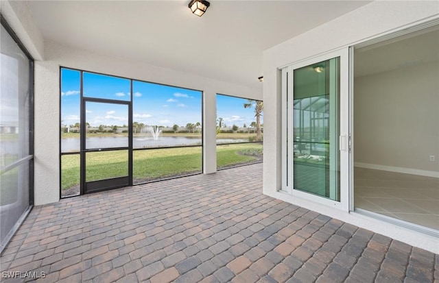 unfurnished sunroom featuring a water view