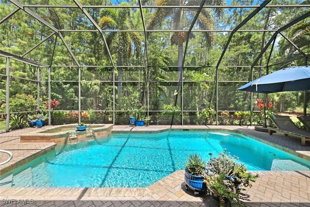 view of pool with glass enclosure and an in ground hot tub