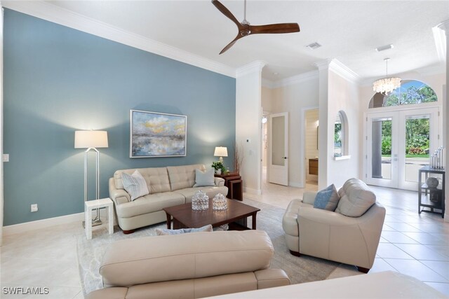 tiled living room featuring crown molding and ceiling fan with notable chandelier