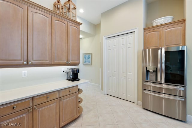 kitchen featuring stainless steel fridge with ice dispenser and light tile patterned flooring