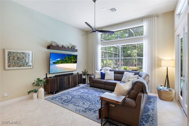 living room with ceiling fan, light tile patterned floors, and plenty of natural light