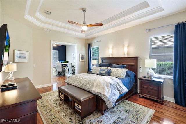 bedroom with ceiling fan, a raised ceiling, and dark hardwood / wood-style floors