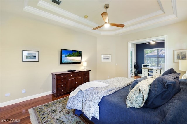 bedroom featuring dark hardwood / wood-style flooring, a raised ceiling, and ceiling fan