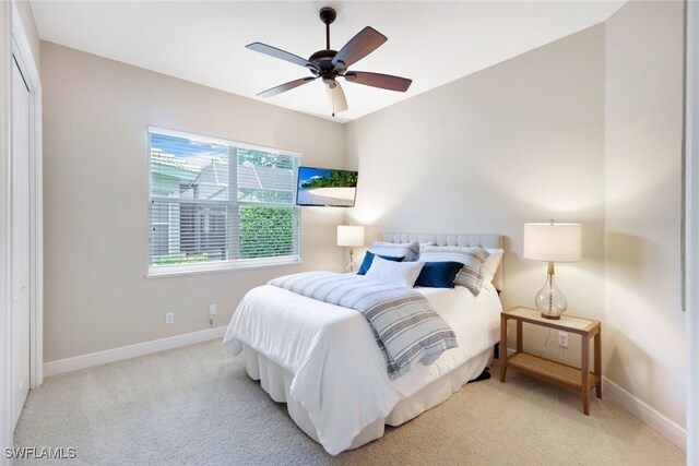 carpeted bedroom featuring ceiling fan and a closet