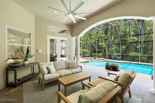 view of pool featuring ceiling fan, glass enclosure, an outdoor hangout area, a patio area, and french doors