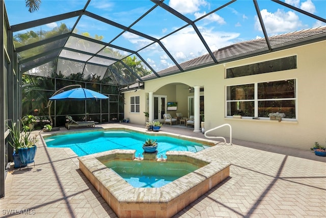 view of swimming pool with glass enclosure, an in ground hot tub, and a patio