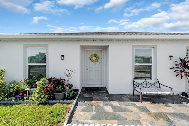 view of exterior entry featuring a patio area