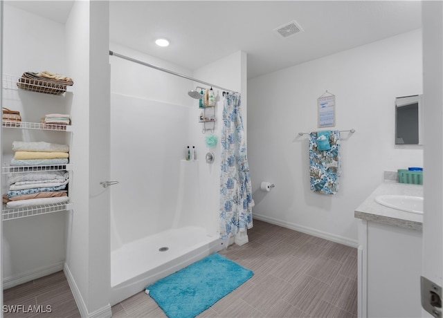 bathroom with tile patterned floors, walk in shower, and vanity