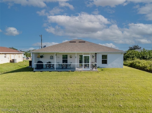 rear view of property featuring a lawn and a patio