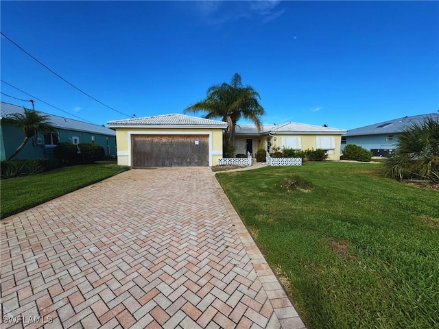 single story home featuring a front yard, decorative driveway, a tile roof, and an attached garage