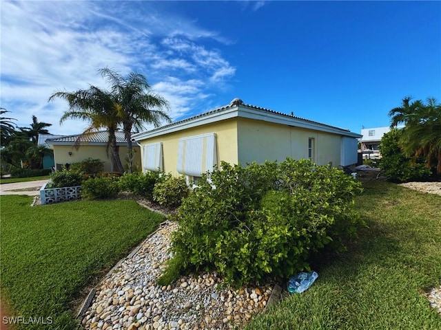 view of property exterior with a lawn and stucco siding