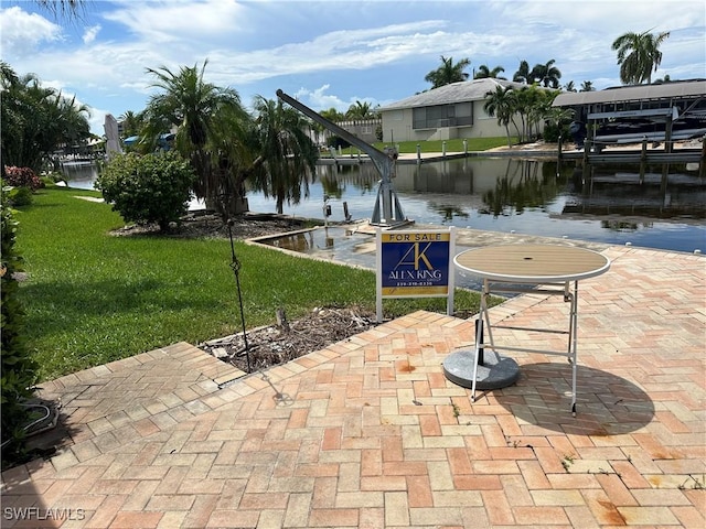 view of property's community featuring a yard, a water view, and a dock