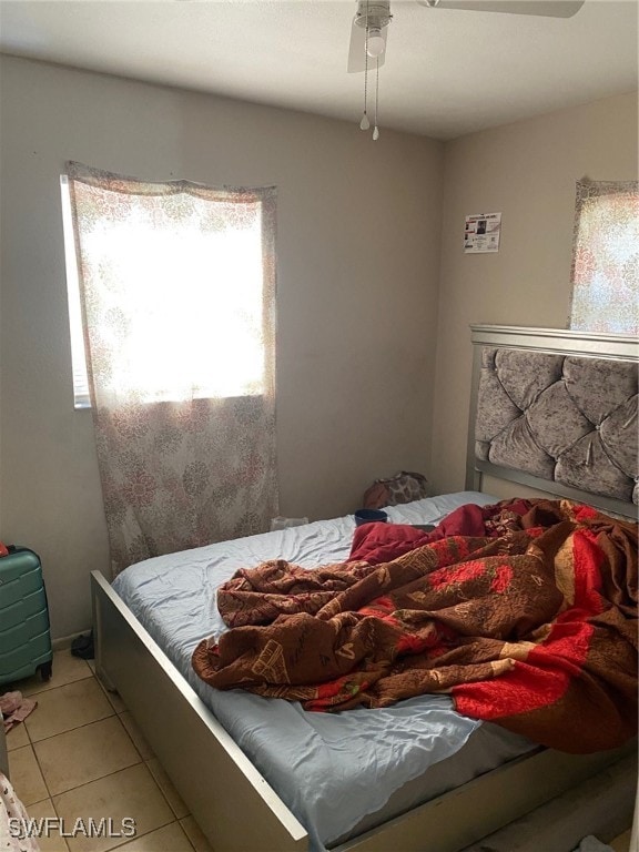 tiled bedroom featuring ceiling fan