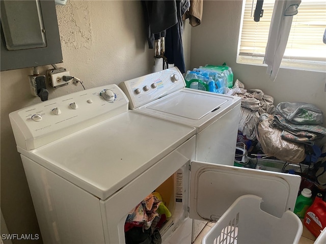 clothes washing area with washer and clothes dryer and electric panel