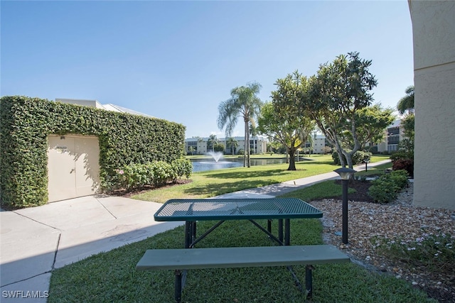 view of property's community featuring a lawn and a water view