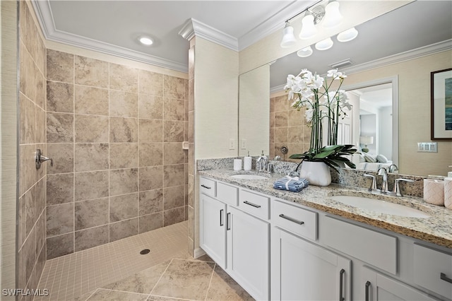 bathroom featuring tile patterned flooring, crown molding, vanity, and tiled shower