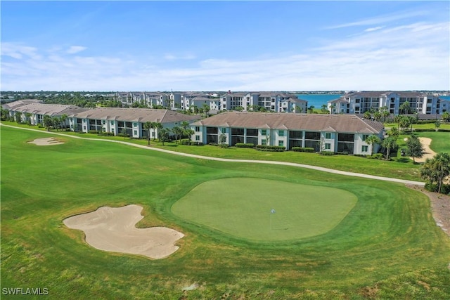 view of property's community with a yard, golf course view, and a water view