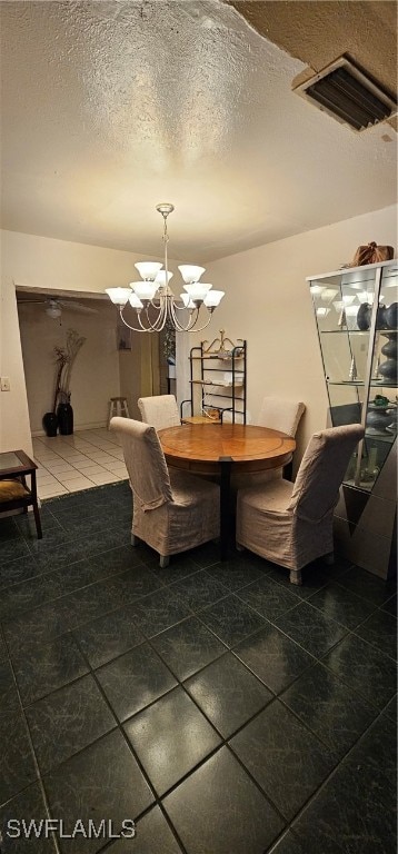 tiled dining area with a notable chandelier and a textured ceiling