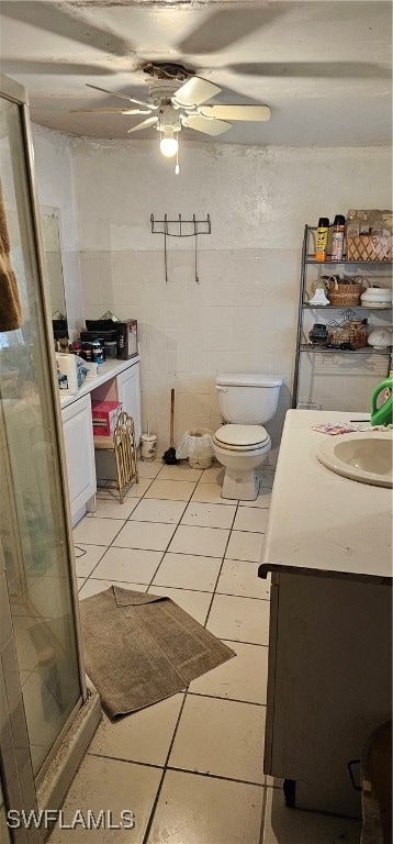 bathroom with ceiling fan, toilet, an enclosed shower, vanity, and tile patterned floors