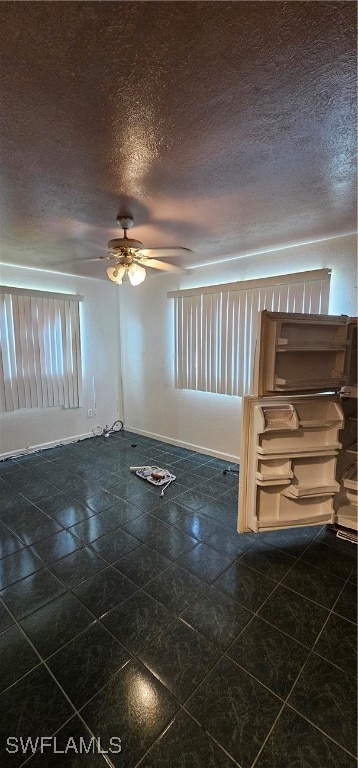 tiled spare room with a textured ceiling and ceiling fan