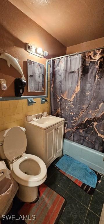 full bathroom with tile walls, tile patterned flooring, vanity, toilet, and shower / bathtub combination with curtain