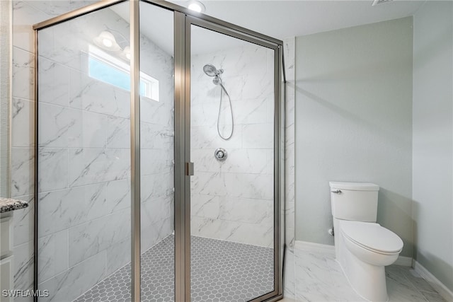 bathroom featuring toilet and a shower with shower door