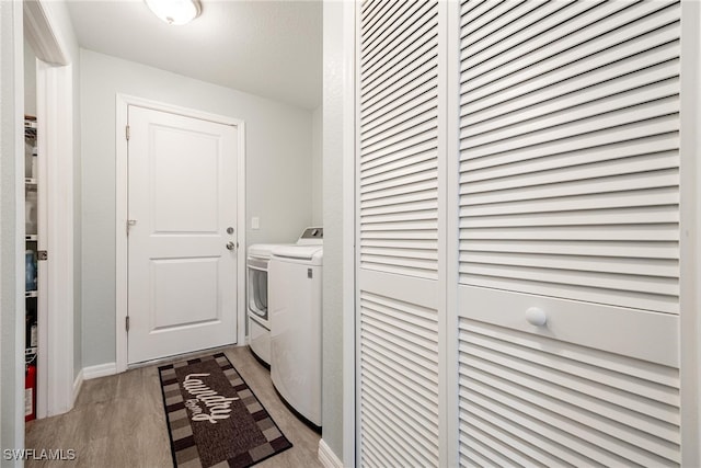 laundry area featuring washing machine and dryer and light hardwood / wood-style floors