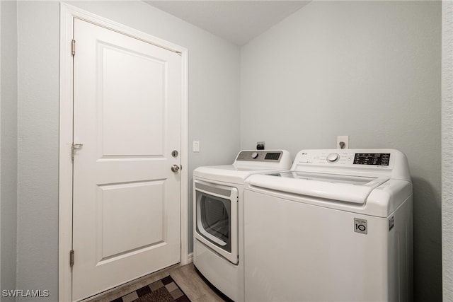 laundry room featuring light wood-type flooring and washer and clothes dryer