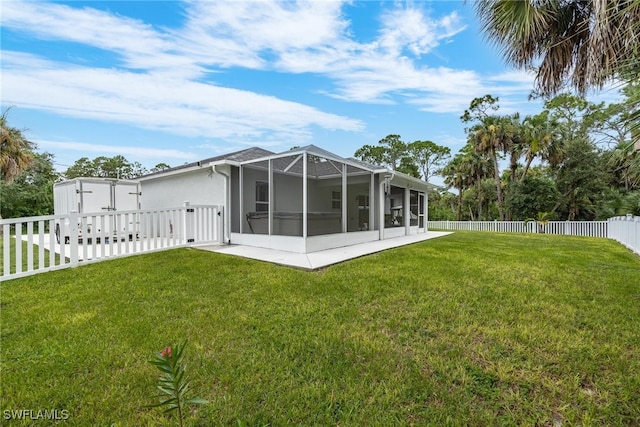 back of house featuring a lawn and a lanai