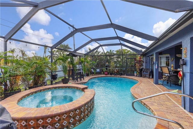 view of swimming pool featuring a lanai, an in ground hot tub, and a patio area