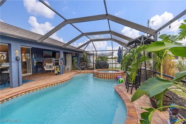 view of pool featuring a lanai, an in ground hot tub, and a patio area