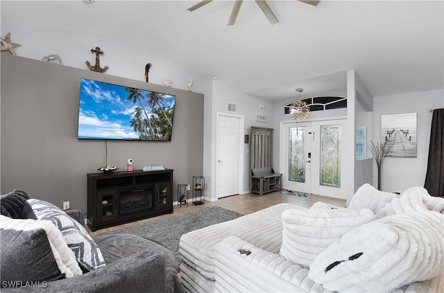 living room with hardwood / wood-style floors, vaulted ceiling, and ceiling fan