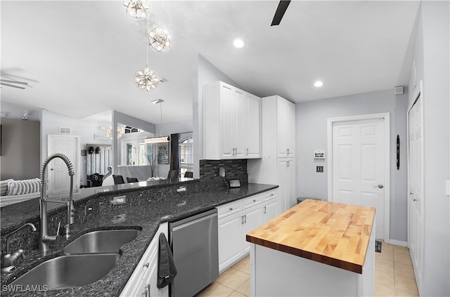 kitchen featuring butcher block counters, dishwasher, hanging light fixtures, sink, and white cabinetry