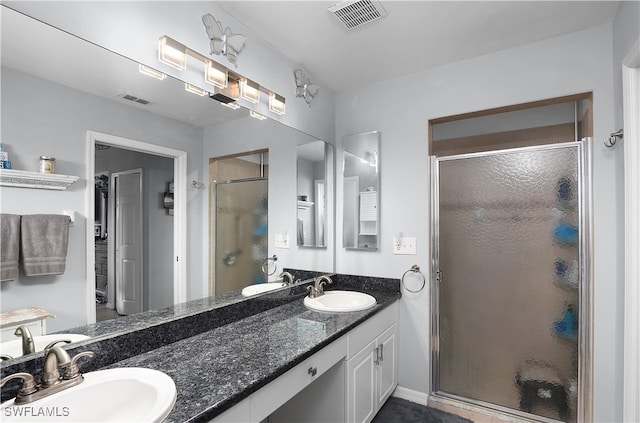 bathroom with a shower with shower door and vanity