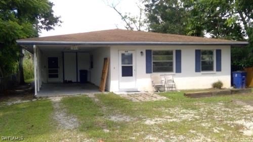 view of front of house featuring a front lawn and a carport