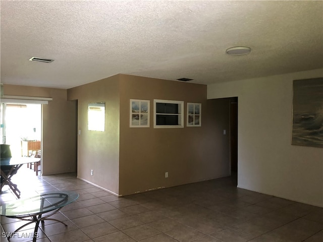 tiled spare room with a textured ceiling