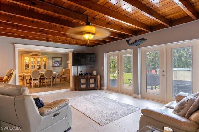 tiled living room with ceiling fan, french doors, beamed ceiling, and wooden ceiling